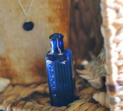 Seaham Waves - Blue Cobalt Earrings Displayed on a Poison Bottle